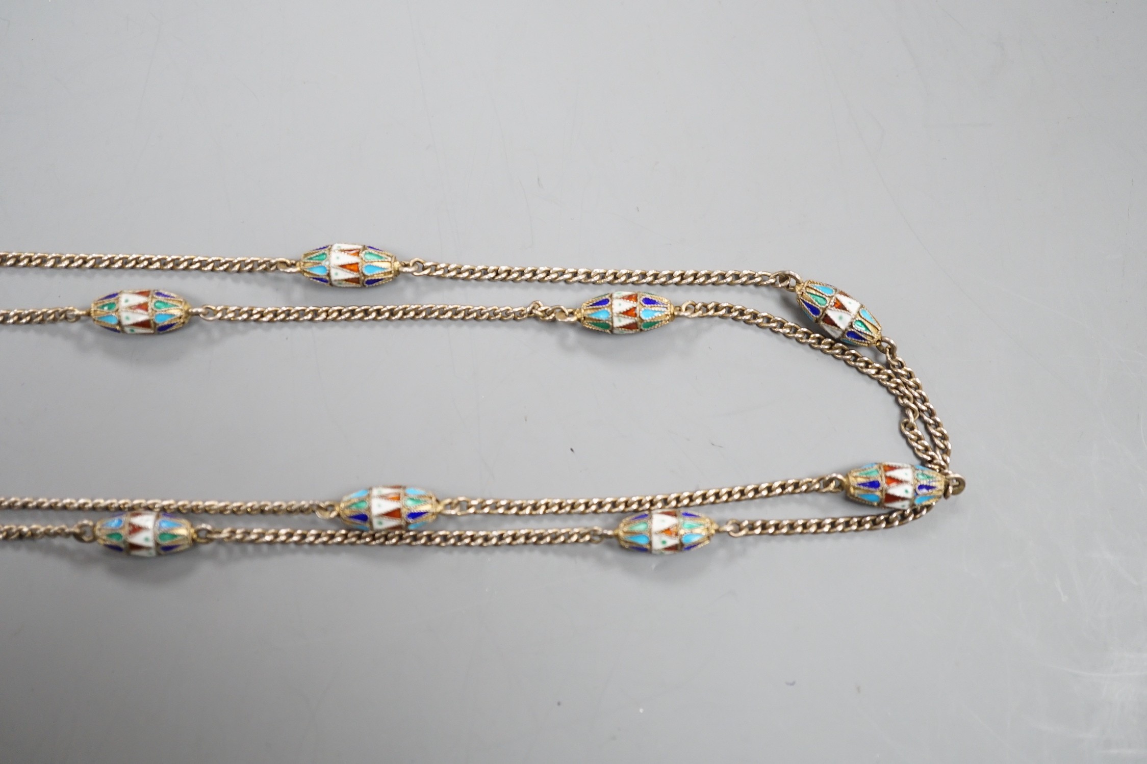 An early 20th century Russian 84 zolotnik and polychrome cloisonné enamel necklace, set with thirteen torpedo shaped enamelled links, 94cm.